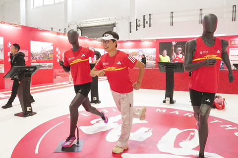 ◎ 十月三十日,一名北京馬拉松參賽者在北京馬拉松博覽會上留影。北京馬拉松博覽會在中國國際展覽中心開幕,本次博覽會包含運動員領物區、北京馬拉松文化展示區、品牌展示區、路跑學院等區域。(新華社記者 鞠煥宗 攝)