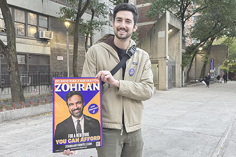 ◎ 據美國紐約市選舉委員會十一月四日公佈的紐約市長初步選舉結果,美國民主黨籍候選人祖赫蘭.馬姆達尼擊敗紐約州前州長、獨立候選人安德魯.科莫,在選舉中勝出。圖為當日,支持者在美國紐約一個投票站外展示候選人祖赫蘭·馬姆達尼的競選海報(手機拍攝)。(新華社發 周煥新 攝)