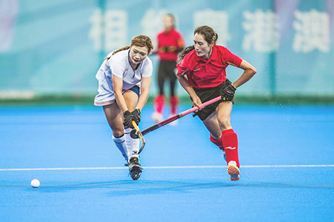 ◎ 十一月十二日,上海隊球員董思雨(左)和遼寧隊球員陳陽拼搶,在廣東省雲浮市舉行的第十五屆全國運動會曲棍球女子五至八排位賽中,遼寧隊二比一戰勝上海隊。(新華社記者 陶亮 攝)