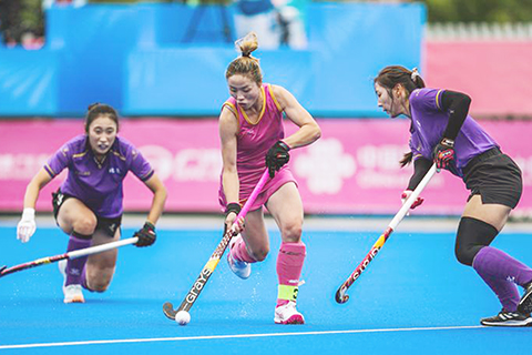 ◎ 十一月十二日,重慶隊球員彭楊(中)進攻。全國運動會女子曲棍球五至八排位賽中,北京隊三比二戰勝重慶隊。(新華社記者 陶亮 攝)