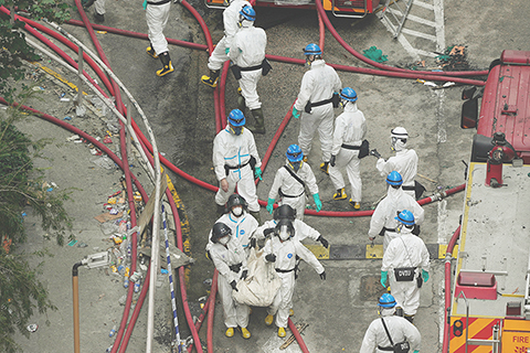 ◎ 十一月三十日,急救人員在現場搬運一個疑似屍袋的物品。(美聯社攝影/Ng Han Guan)