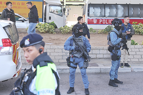 ◎ 十二月十五日,壹傳媒創辦人黎智英與《蘋果日報》三間相關公司涉嫌串謀勾結外國勢力案今早宣佈判決,三名國安法指定法官裁定黎智英兩項串謀勾結外國勢力罪及一項串謀發佈煽動刊物罪成立。圖為押送黎智英的囚車駛離西九龍裁判法院,反恐特勤隊警員持槍戒備。(香港中通社記者謝光磊 攝)