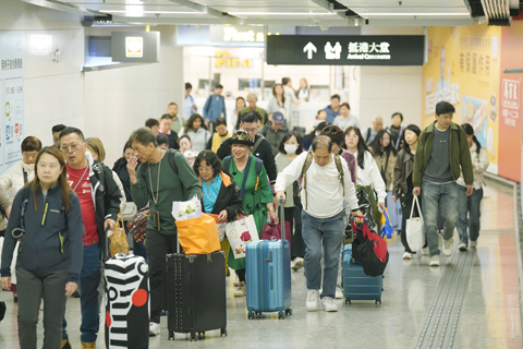 ◎ 十二月廿八日,香港西九龍高鐵站,聖誕假期尾聲,陸續有市民和旅客抵港。入境處表示,截至上午十時,有超過十七萬人次經各管制站出入境,其中超過七萬五千人次入境。圖為傍晚時份,抵港的市民與遊客拖著行李走出高鐵站。(香港中通社記者陳奕啟 攝)