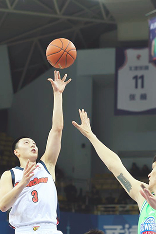 ◎ 十二月三十日,廣東東陽光隊球員胡明軒(左)中投籃。CBA第八輪比賽中,廣東東陽光隊九十八比七十四戰勝天津先行者隊。新華社記者孫凡越攝