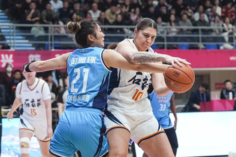 ◎ 一月四日,石家莊英勵隊球員艾米莉(右)在比賽中拼搶。在山東臨沭舉行中國女子籃球聯賽(WCBA)常規賽第十二輪比賽中,山東赤水河酒隊一百零六比九十三戰勝石家莊英勵隊。(新華社記者 朱崢 攝)
