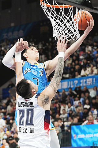 ◎ 一月九日,CBA常規賽比賽中,北京北汽隊主場八十五比八十七不敵山東高速隊。圖為主場北京北汽隊曾凡博(藍衣)上籃。(中新社記者張祥毅 攝)