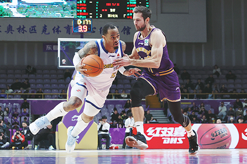 ◎ 一月二十一日,CBA常規賽比賽中,北京控股隊主場七十九比一百零二負於浙江方興渡隊(廣廈)。圖為浙江方興渡塔克(白衣)在比賽中帶球進攻。(中新社記者 韓海丹 攝)
