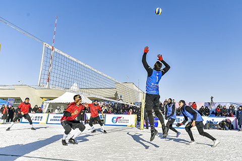 ◎ 一月二十二日,「一帶一路.絲綢之路」行二0二六年中國國際雪地排球邀請賽,在新疆阜康市天山天池國際滑雪場開賽。來自中國、法國等國家的十七支代表隊,將在為期四天的比賽中展開激烈角逐。圖為俄羅斯男隊(藍黑球衣)與中國新疆男子一隊(紅黑球衣)正在比賽。(中新社記者 劉新 攝)