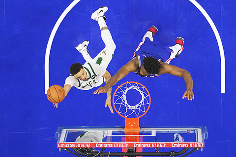 ◎ 七六人巨頭艾比迪(右)力阻公鹿羅連斯上籃。(美聯社)