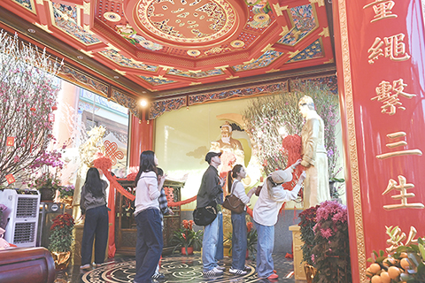 ◎ 二月十四日為西方情人節。當天,有民眾到香港黃大仙祠的月老殿內拜月老,繫上紅線祈求好姻緣。(中新社記者 李志華 攝)