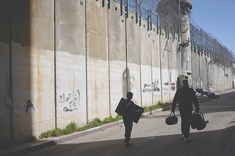 ◎ 二月十五日,巴勒斯坦人沿著約旦河西岸和東耶路撒冷貝特哈尼納社區之間的隔離牆行走。(美聯社圖片/Ohad Zwigenberg)