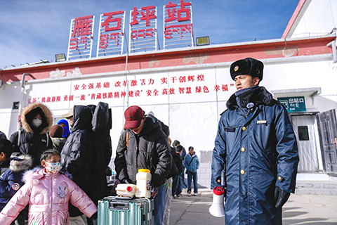 青藏鐵路雁石坪站客運員桑杰平措(右一)在火車到達前組織乘客到站台候車。(中新社記者 李林 攝)