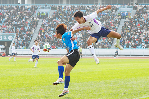 ◎ 三月二十五日,江蘇常州與湖南永州足球友誼交流賽在常州奧體中心體育場舉行,最終,常州隊一比0戰勝永州隊。比賽過程中,雙方球員拼勁十足,觀賽球迷熱情高漲。圖為常州隊球員(白衣)與永州隊球員(藍衣)拼搶。(中新社記者 泱波 攝)