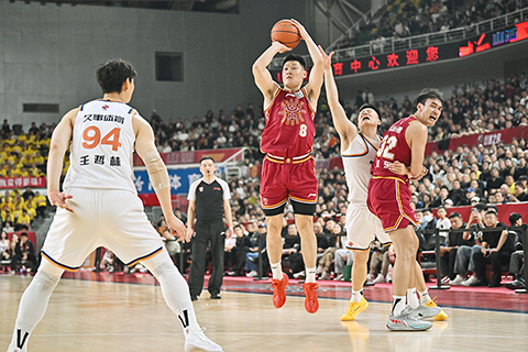 ◎ 三月二十九日,山西隊球員張寧(紅衣)投籃。CBA常規賽第三十二輪比賽中,山西汾酒隊主場以九十六比一百不敵上海久事隊。(中新社記者韋亮攝)