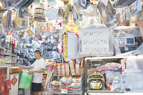 ◎ 四月五日,清明節紙紮祭品隨著時代轉變遷,近年科技產品、黃金製品及寵物周邊等成為新趨勢,既保留傳統祭祀意義,同時融入新元素,令清明祭祖文化與時俱進。圖為上環一紙紮鋪擺滿了各式新元素紙紮品供市民挑選。(香港中通社記者陳奕啟 攝)