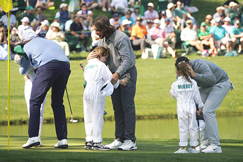 ◎ 四月八日,上屆大師賽冠軍羅里·麥克羅伊(右一)等球員在參加三桿洞挑戰賽時與各自的孩子擁抱交流。在美國佐治亞州奧古斯塔的國家高爾夫俱樂部,第九十屆美國大師賽在正式比賽前舉行了傳統的三桿洞挑戰賽。相較大師賽正賽,以親情、愛情、友情為主題的三桿洞挑戰賽非常輕鬆,充滿娛樂性。眾多球員都會選擇讓家人、愛人或友人擔當球童,一起感受大師賽。本屆大師賽正賽將於四月九日開賽。(新華社記者 吳曉凌 攝)