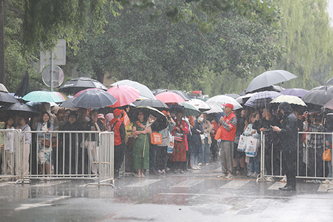 ◎ 六月七日,遼寧省瀋陽市東北育才學校考點外,家長在雨中等待考生。當日,二0二六年全國高考拉開帷幕。(中新社記者 于海洋 攝)