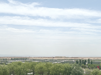 7月9日,位於鄂爾多斯市的準能集團生物多樣性主題公園及千畝果園,遠處為礦區正在進行復墾綠化的排土場。(中新社記者 王夢瑤攝)