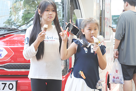 ◎ 七月廿三日,踏入二十四節氣中的「大暑」,香港日間天氣酷熱,市區最高氣溫升至約攝氏卅二至卅四度,新界內陸地區更可能達攝氏卅五度。圖為天氣炎熱,遊客在購買冰淇淋的同時打卡「富豪雪糕」車。(香港中通社記者 鄧梓傑 攝)
