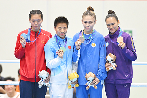 ◎ 十月二日,亞運會拳擊項目女子五十一公斤級決賽中,中國隊選手、奧運冠軍吳愉以五比0擊敗越南選手阮氏心,奪得冠軍。圖為吳愉(左二)登上領獎台。(中新社記者 趙文宇 攝)